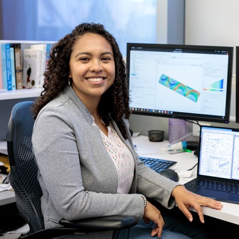 Viviana Palacio-Betancur at her workstation with renderings of her work